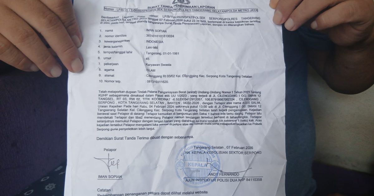 Iman Sopian, saat menunjukkan bukti laporan polisi usai diduga dianiaya pejabat Dispora Tangsel.